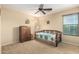 Cozy bedroom with a ceiling fan, a window with blinds, and an antique wooden dresser with drawers at 38397 N Nuevo Laredo Ln, San Tan Valley, AZ 85140