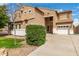 Lovely tan two-story home with a three-car garage and well-manicured front yard at 38397 N Nuevo Laredo Ln, San Tan Valley, AZ 85140