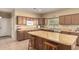 Eat-in kitchen featuring an island with bar stool seating, plenty of natural light, and ample cabinet space at 38397 N Nuevo Laredo Ln, San Tan Valley, AZ 85140