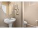 Powder room with pedestal sink and decorative wall art offers a practical and aesthetic touch at 38397 N Nuevo Laredo Ln, San Tan Valley, AZ 85140
