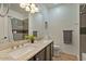 Bathroom featuring dual sinks with granite countertops, updated fixtures, and a tiled shower with glass doors at 384 N Scott Dr, Chandler, AZ 85225