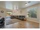 Inviting living room features a large sectional sofa, wood flooring, and a sliding glass door to the backyard pool at 384 N Scott Dr, Chandler, AZ 85225