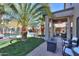 Spacious backyard featuring a pool, mature palm trees, and a covered patio with comfortable seating at 45176 W Alamendras St, Maricopa, AZ 85139