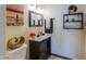 Charming powder room with dark wood vanity, decorative mirror, and stylish decor at 45176 W Alamendras St, Maricopa, AZ 85139