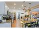 Well-lit kitchen features granite counters, pendant lighting, stainless appliances, and open layout with pantry access at 45176 W Alamendras St, Maricopa, AZ 85139