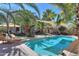 Stunning backyard oasis featuring a private pool, mature landscaping, and shaded seating areas at 45176 W Alamendras St, Maricopa, AZ 85139