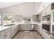 Bright modern kitchen with stainless steel appliances, light-gray cabinets, white countertops, and wood-look floors at 5140 S Tanglewood Dr, Chandler, AZ 85248