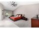 Bright main bedroom with a ceiling fan, sliding glass doors to the backyard, and neutral carpet at 5140 S Tanglewood Dr, Chandler, AZ 85248