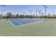 Well-maintained community tennis court with lighting for evening play and shaded seating area at 5140 S Tanglewood Dr, Chandler, AZ 85248