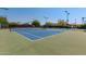Well-maintained community tennis court with lighting for evening play and shaded seating area at 5140 S Tanglewood Dr, Chandler, AZ 85248