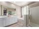 Bright bathroom showcasing double sinks, a soaking tub, a glass-enclosed shower, and neutral tile at 5259 S Hadron --, Mesa, AZ 85212