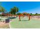Modern playground with green safety surface and bright orange climbing features under a clear blue sky at 5259 S Hadron --, Mesa, AZ 85212