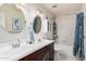 Bathroom featuring dual sinks, granite counters, and shower with white tile at 8554 E Mcdonald Dr, Scottsdale, AZ 85250