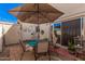 Outdoor patio with table, chairs, and large umbrella at 8554 E Mcdonald Dr, Scottsdale, AZ 85250