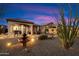 Beautiful backyard with desert landscaping, water feature, outdoor kitchen, and cozy seating area perfect for entertaining at 8661 E Ivy St, Mesa, AZ 85207