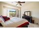 Bright bedroom featuring a large window and dark wood furniture with a decorative ceiling fan at 8661 E Ivy St, Mesa, AZ 85207