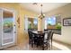 Inviting dining area with a table for six and an abundance of natural light from large windows at 8661 E Ivy St, Mesa, AZ 85207