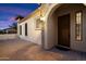 Inviting covered front porch with a brick-paved walkway leading to the warm-toned front door at 8661 E Ivy St, Mesa, AZ 85207