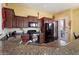 Spacious kitchen featuring granite countertops, updated appliances, and a door to the outside at 8661 E Ivy St, Mesa, AZ 85207