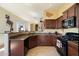 Well-equipped kitchen with black appliances, dark wood cabinets, and granite countertops at 8661 E Ivy St, Mesa, AZ 85207