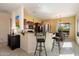 Open-concept kitchen featuring a breakfast bar, dark cabinetry, and adjacent dining area with natural light at 8661 E Ivy St, Mesa, AZ 85207