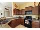 Modern kitchen with wood cabinetry, granite countertops, and updated appliances at 8661 E Ivy St, Mesa, AZ 85207