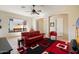 Bright living area with a red leather sofa and contemporary decor with a view to the entry at 8661 E Ivy St, Mesa, AZ 85207
