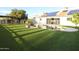 Spacious backyard featuring a pool, pergola, lush green lawn, and desert landscaping at 9732 N Penworth Dr, Casa Grande, AZ 85122