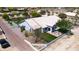 A charming desert home featuring a white tiled roof, lush green front lawn, and a cozy outdoor seating area at 9732 N Penworth Dr, Casa Grande, AZ 85122