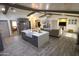 Open kitchen with a large island, gray cabinets, stainless steel appliances, and wood-look tile flooring at 9732 N Penworth Dr, Casa Grande, AZ 85122