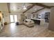 Open-concept living space with wood-look tile floors, wood beams, and comfortable seating at 9732 N Penworth Dr, Casa Grande, AZ 85122