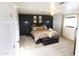 Bedroom featuring a king bed with a black accent wall, fan, and carpet at 9732 N Penworth Dr, Casa Grande, AZ 85122