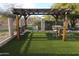Wooden pergola with outdoor seating provides a relaxing space in the backyard at 9732 N Penworth Dr, Casa Grande, AZ 85122