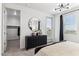 Light filled bedroom with modern chandelier, dark dresser and doorway leading to closet and outside at 9807 S 11Th St, Phoenix, AZ 85042