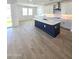 Bright kitchen features wood floors, island with sink, and white cabinets at 9807 S 11Th St, Phoenix, AZ 85042