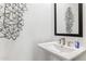 Stylish powder room featuring a pedestal sink, geometric wall decor and rectangular mirror at 9807 S 11Th St, Phoenix, AZ 85042