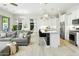 Spacious living room featuring a kitchen with stainless steel appliances, and a comfortable gray couch at 1816 N Bernard Cir, Mesa, AZ 85207