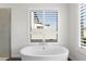 Elegant bathroom with a standalone tub positioned under a window with shutter and wood-look tile at 3856 E Sagebrush St, Gilbert, AZ 85296