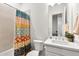 Well-lit bathroom featuring a tub with colorful shower curtain, a modern vanity, and neutral finishes at 3856 E Sagebrush St, Gilbert, AZ 85296