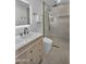 Bright bathroom featuring single sink vanity with a glass shower with tile surround and rainfall shower head at 8215 E Virginia Ave, Scottsdale, AZ 85257