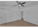 Bright bedroom with hardwood floors, closet with sliding doors, white walls, and ceiling fan at 8215 E Virginia Ave, Scottsdale, AZ 85257