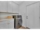 The laundry room includes custom cabinets for storage, folding area and modern washer and dryer at 8215 E Virginia Ave, Scottsdale, AZ 85257