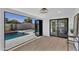 Bright room with hardwood floors, opening to a pool and patio through folding glass doors, creates an indoor-outdoor feel at 8215 E Virginia Ave, Scottsdale, AZ 85257