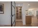 Modern wine cellar features black metal racks and glass door, adding a touch of elegance and functionality to the home at 8215 E Virginia Ave, Scottsdale, AZ 85257