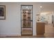 Modern wine cellar features black metal racks and glass door, adding a touch of elegance and functionality to the home at 8215 E Virginia Ave, Scottsdale, AZ 85257