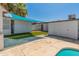 Fenced backyard featuring artificial turf, shade cover, and desert landscaping at 1112 W Farmdale Ave, Mesa, AZ 85210