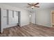 Spacious bedroom featuring wood-look floors, a ceiling fan, and custom closet organizers at 1112 W Farmdale Ave, Mesa, AZ 85210