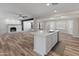 Open-concept kitchen with white cabinets, island sink, and a view of the living area fireplace at 1112 W Farmdale Ave, Mesa, AZ 85210
