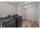 Laundry room featuring sleek, modern washer and dryer with wood-look floors at 1112 W Farmdale Ave, Mesa, AZ 85210