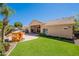 Expansive backyard featuring green grass, palm trees, and an outdoor patio area at 11224 E Carol Ave, Scottsdale, AZ 85259